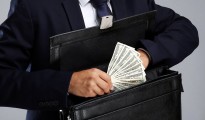Business man hiding money in briefcase on gray background