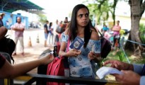 A Venezuelan woman shows her passport and identity card at the Pacaraima border control, Roraima state