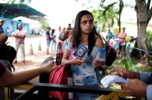 A Venezuelan woman shows her passport and identity card at the Pacaraima border control, Roraima state