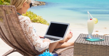 Business woman working with computer on the beach